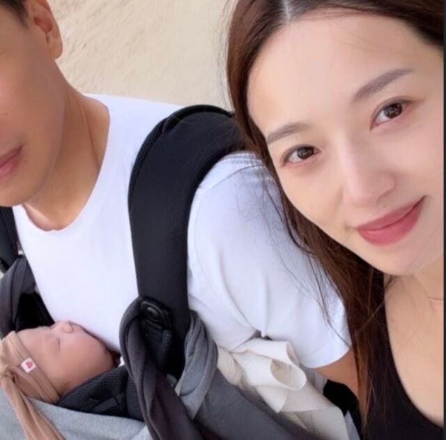 抱っこひもの中で眠る息子と並ぶキム・ミンギョン