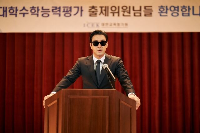 映画『修能、出題の秘密』で、サングラス姿の国家情報院要員として演壇に立つチェ・シウォン