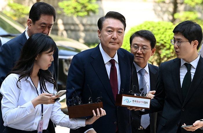 윤석열 전 대통령이 12일 서울 서초구 중앙지방법원에서 열린 내란 우두머리 혐의,직권남용 권리행사방해 혐의 사건 3차 공판에 출석,취재진의 질문을 받으며 이동하고 있다.ⓒ연합뉴스