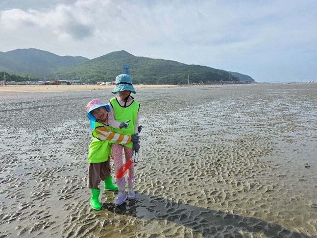 갯벌에서 누나를 꼭 껴안고 좋아하는 손자 ⓒ