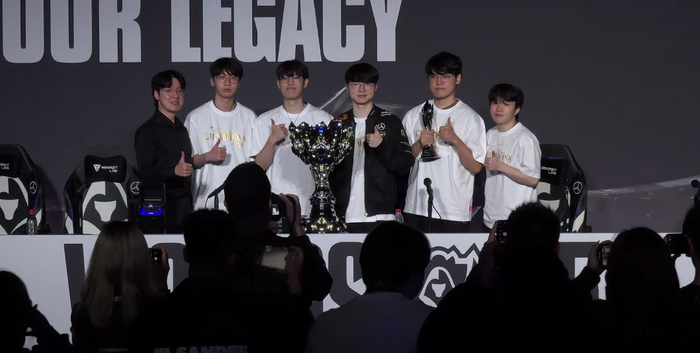 T1 선수단이 9일 중국 청두에서 열린 2025 리그 오브 레전드 월드 챔피언십(롤드컵) 결승전에서 우승한 후 소환사의 컵을 앞에 두고 기념촬영을 하고 있다. 온라인 기자회견 캡처
