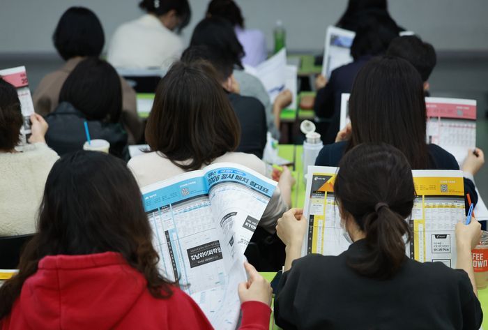 이투스에듀 주최로 지난달 15일 서울 강남하이퍼학원 본원에서 열린 '2026 수능 가채점 설명회'에 참석한 수험생과 학부모들이 대학 배치 참고표를 살피고 있다.ⓒ연합뉴스