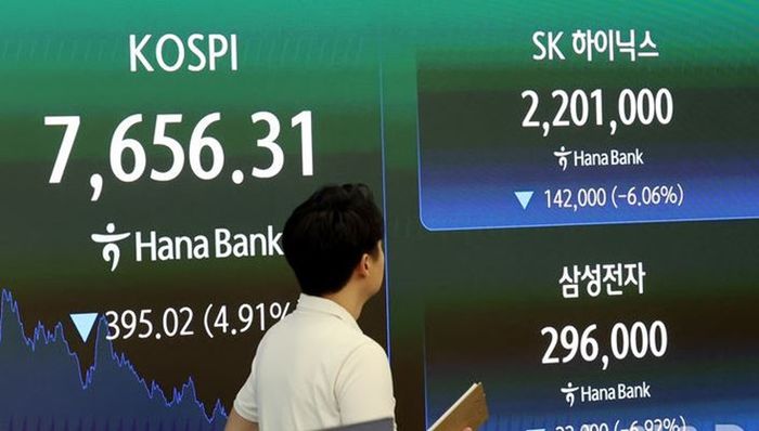 7일 오후 서울 중구 하나은행 본점 딜링룸에서 딜러가 코스피가 7656.31로 마감된 증시 시황판을 바라보고 있다.ⓒ 뉴시스