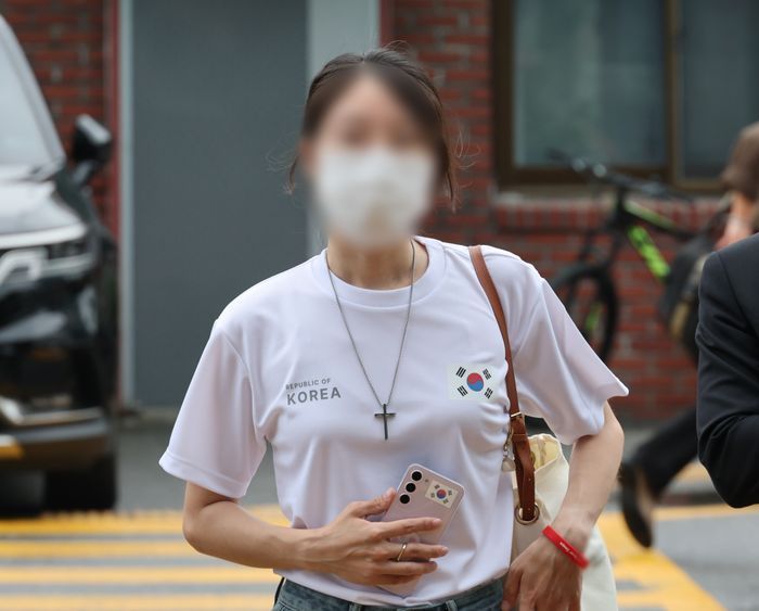 6·3 지방선거 개표소로 사용된 올림픽공원 핸드볼경기장 문 앞에서 체육단체 직원들의 장내 사무실 진입을 막아 업무 방해 혐의를 받는 30대 여성이 지난 10일 서울 송파경찰서에서 조사받기 위해 출석하고 있다.ⓒ연합