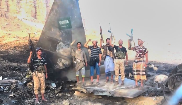 지난달 16일 예멘 후티 반군 전투원들이 사우디아라비아 F-15 전투기 잔해 앞에서 구호를 외고 있다. ⓒAP/뉴시스
