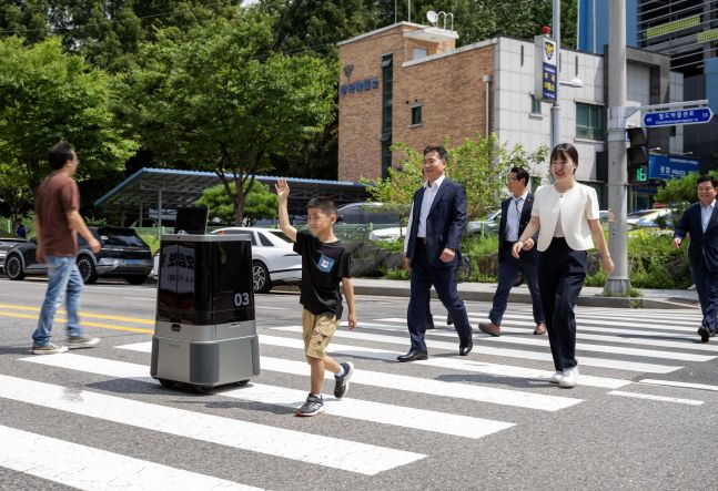 ◆…현대차·기아는 9일 경기도 의왕시 부곡파출소 앞 횡단보도에서 자율주행 배송로봇의 횡단보도 주행 실증 시연에 성공하며 로봇 지능 사회에 한발 다가섰음을 알렸다. 사진=현대차·기아 로보틱스랩 자율주행 배송로봇이 시민