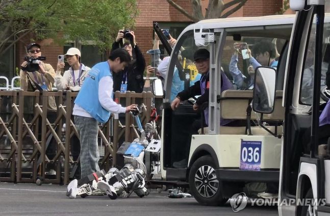 ◆…'제2회 휴머노이드 로봇 하프마라톤 대회'에 참가한 한 로봇이 회전로를 돌지 못하고 울타리에 부딪혀 쓰러져있다. 사진=연합뉴스