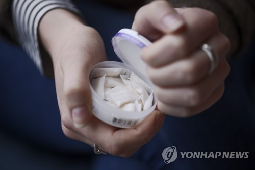 ◆…스웨덴 스톡홀름에서 한 여성이 입안에 넣어 사용하는 '화이트 스누스' 제품을 열고 있다. 유럽연합(EU)은 니코틴 파우치를 비롯한 새로운 니코틴 제품에도 공동 최저세율을 적용하는 방안을 추진하고 있다. (사진=A