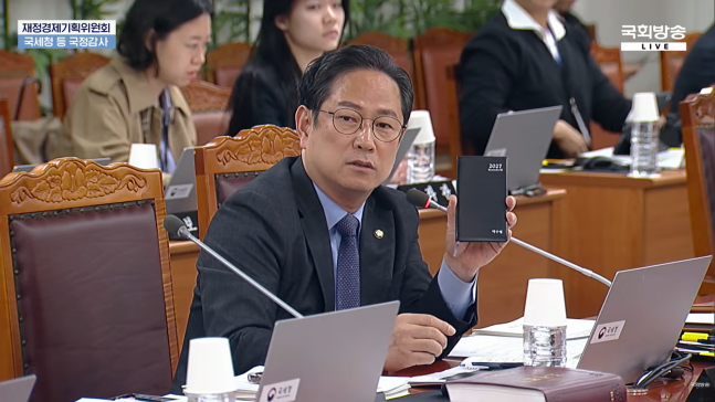 ◆…박수영 국민의힘 의원이 13일 국회 재정경제기획위원회의 국세청 국정감사에서 국세청이 의원들에게 제공한 수첩을 들어 보이며 과도한 의전 문제를 지적하고 있다. (사진=국회방송 화면 캡처)