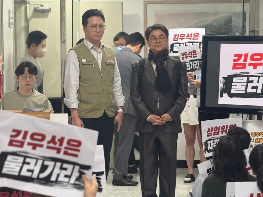 김우석 방송미디어통신심의위원회 위원(오른쪽)이 19일 서울 양천구 방송회관에서 열릴 방미통위 전체회의를 앞두고 사퇴를 요구하는 노조원들 앞에 서 있다./김한내 기자