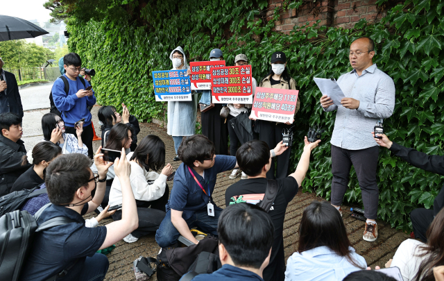 5월 21일 서울 용산구 이재용 삼성전자 회장 자택 앞에서 열린 삼성전자 주주 총결집 집회에서 삼성전자 주주단체인 '대한민국 주주운동본부' 관계자들이 손팻말을 들고 있다.이날 주주운동본부는 삼성전자 노사의 임금협상