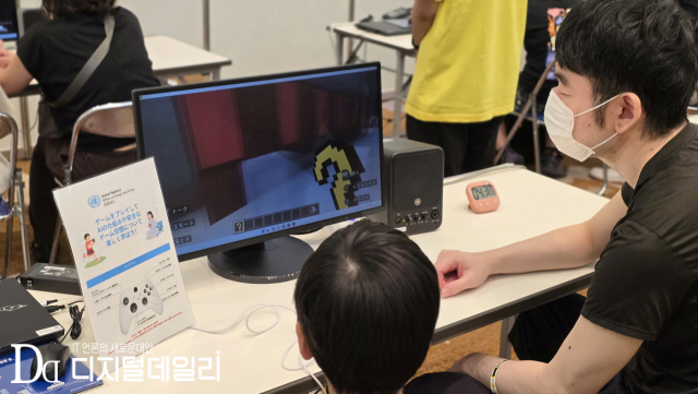 9월19일(현지시각) 'TGS 2026' 패밀리 게임 파크 현장. 부모와 아이가 함께 '마인크래프트'를 활용한 AI 교육 프로그램을 체험하고 있다. [사진=이학범기자]