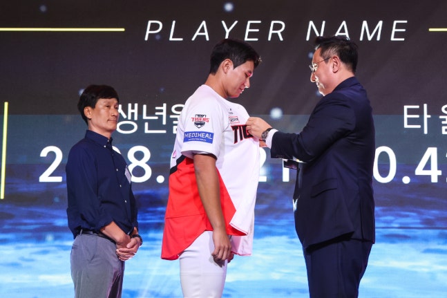 2027 신인 드래프트에서 KIA에 1라운드 지명된 이호민에게 심재학 KIA 단장이 유니폼을 입혀주고 있다. KIA 타이거즈 제공