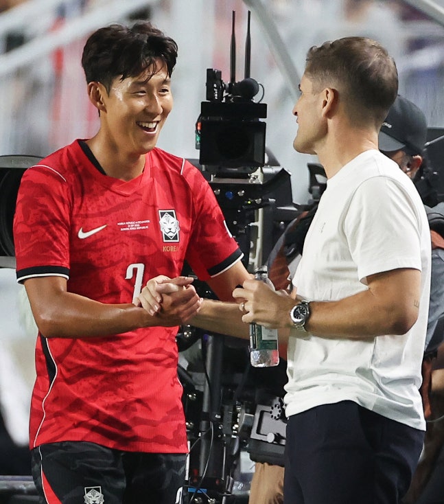 로베르트 모레노 축구대표님 감독이 24일 수원월드컵경기장에서 열린 에콰도르전에서 교체된 손흥민과 환하게 웃으며 손을 맞잡고 있다. 연합뉴스