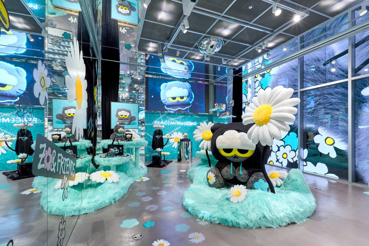 PEACEMINUSONEとZO&FRIENDSの装飾で彩られたポップアップ会場。デイジーを頭に飾ったキャラクターの大型ぬいぐるみが置かれている。