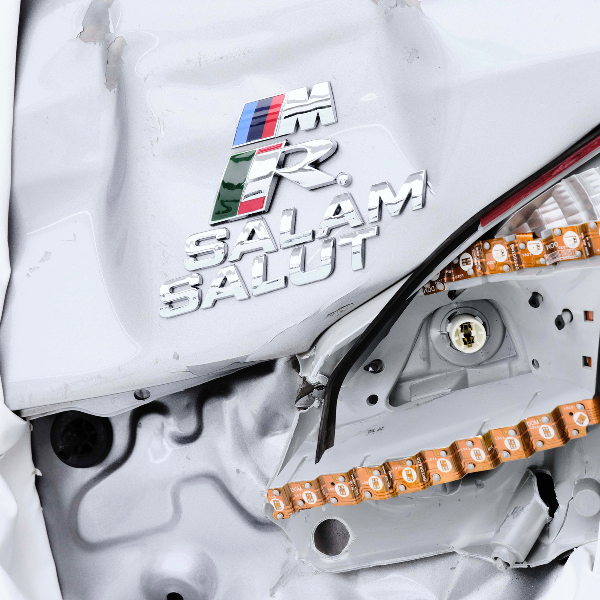 事故車両から取り出されたBMW Mのロゴ付き部品を用いた「Psycho」のアートワーク