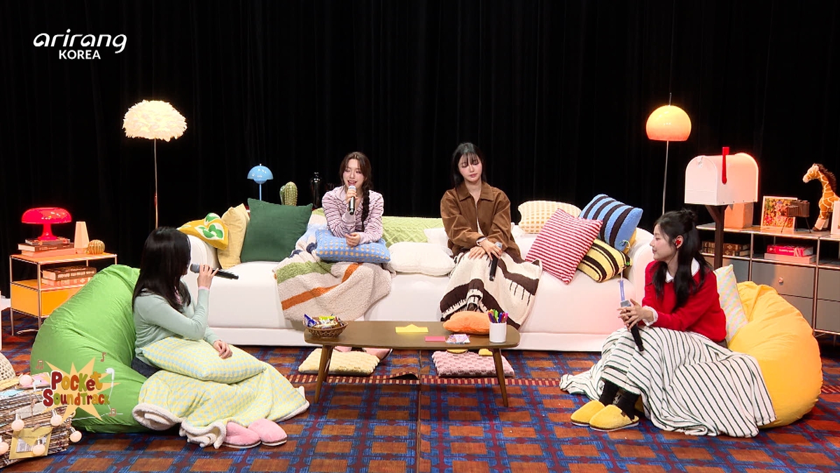 Arirang TVのロゴが入ったセットで、ソファやクッションに座って話すFIFTY FIFTYの4人