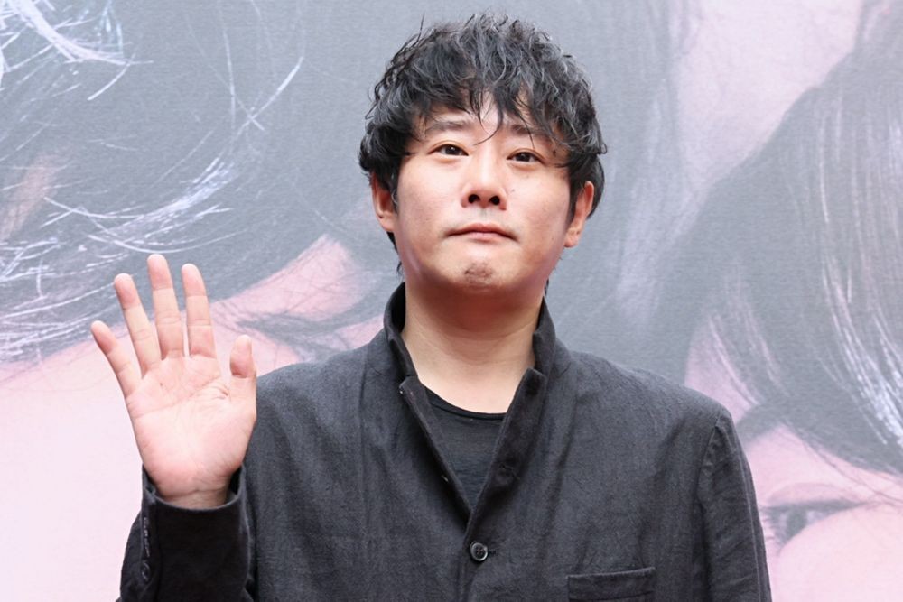 映画「그대, 별처럼」の背景パネル前で手を振る藤井道人監督