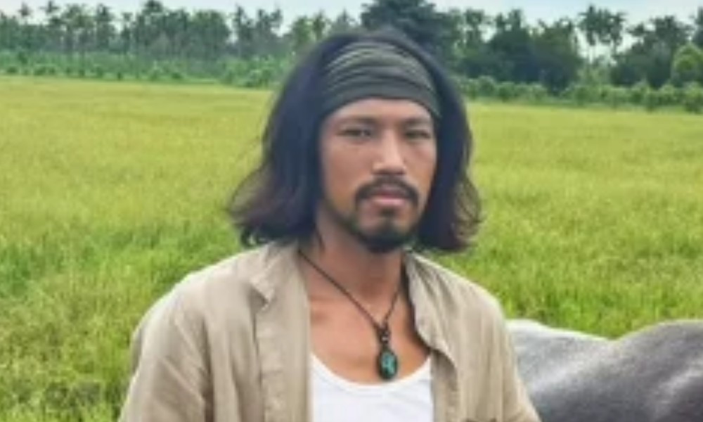 草地を背景に座る俳優キム・ミン