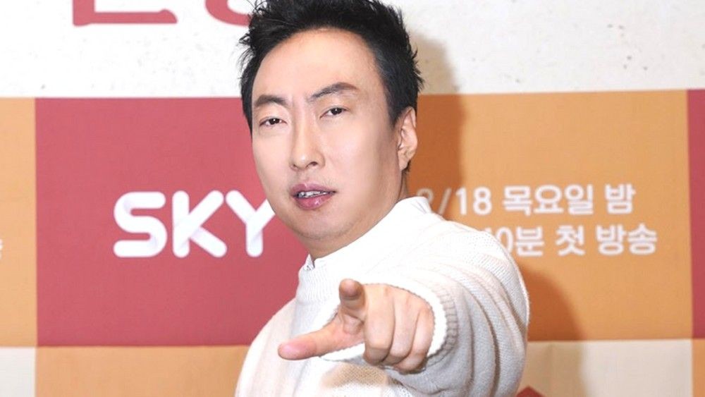白いセーター姿でカメラを指さすパク・ミョンス