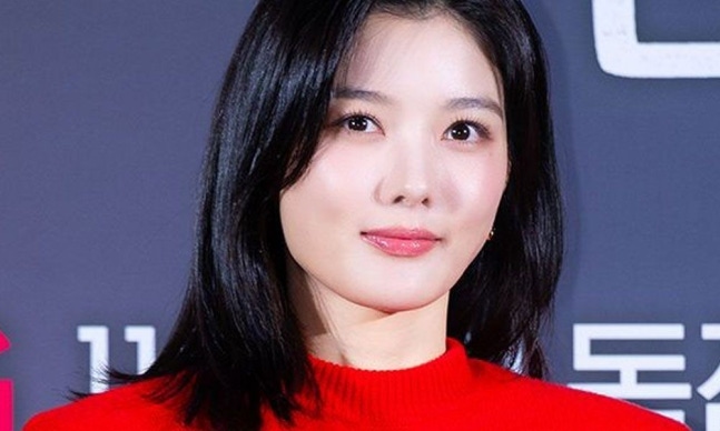 赤いセーター姿でカメラに微笑むキム・ユジョン
