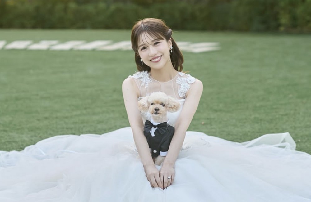 ウェディングドレス姿で愛犬を抱く篠崎彩奈
