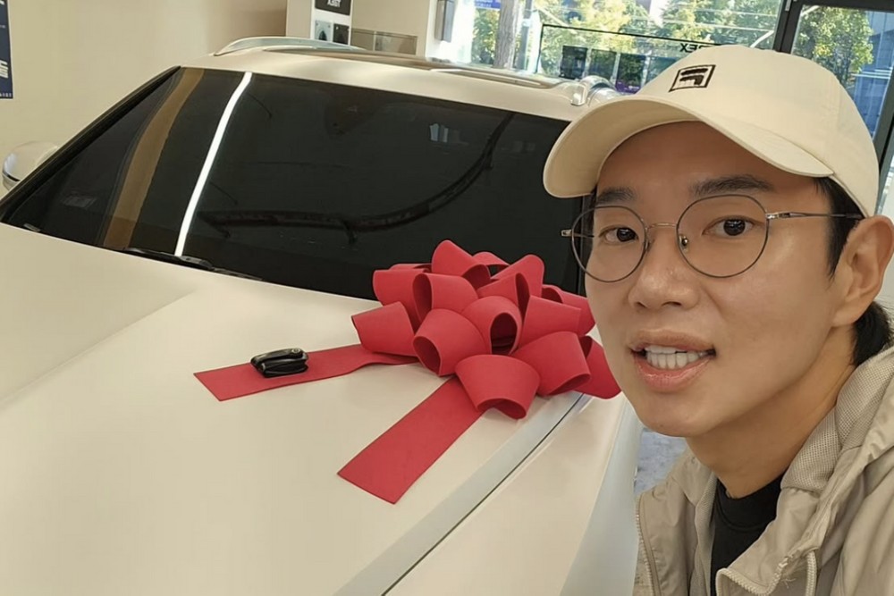 白いベントレーの横で自撮りするチャン・ソンギュ。車体には赤いリボンが飾られている
