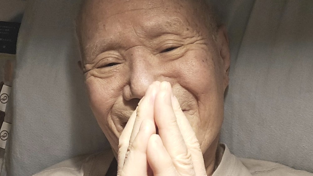 手を合わせるちばてつやさんの写真