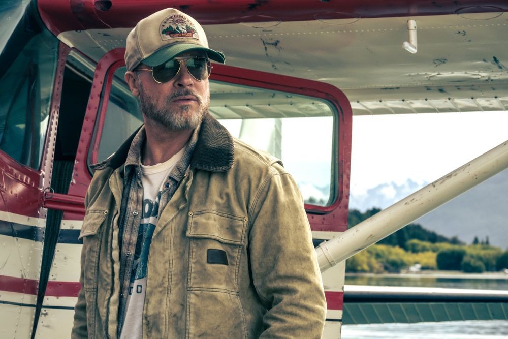 映画「ハート・オブ・ビースト」で飛行機のそばに立つブラッド・ピット