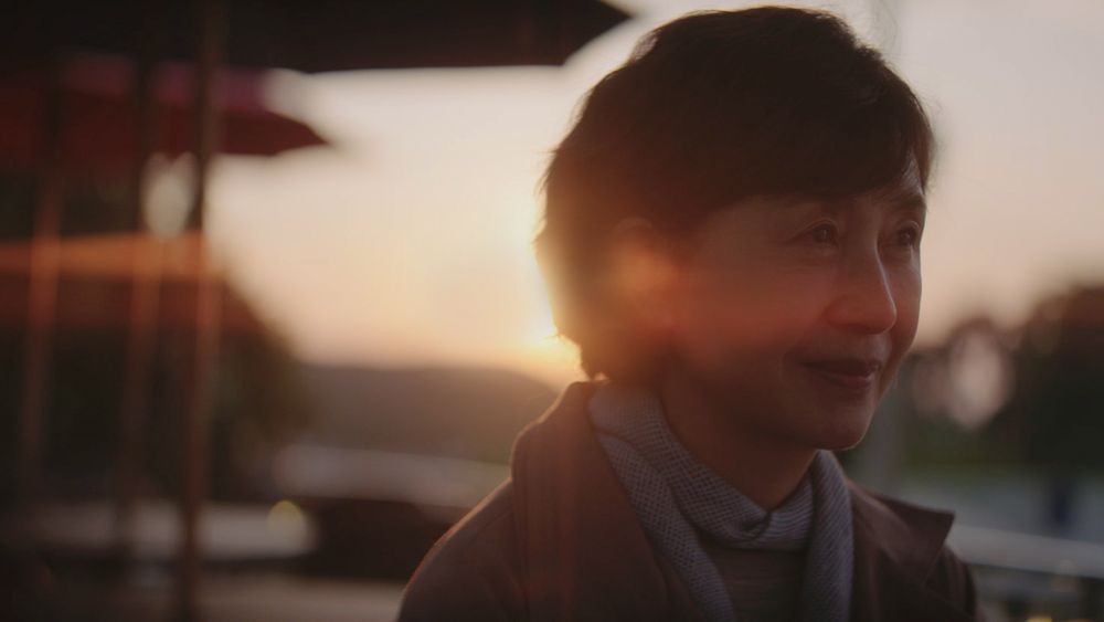 映画『流れる旅路』で夕景を背にするジャスティン・H・ミン