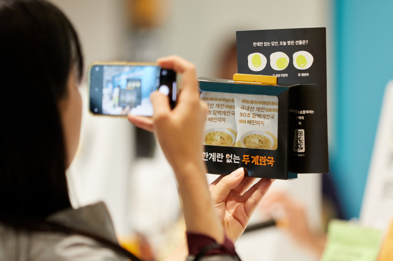 9일 성수동에서 열리는‘배민 계란프라이데이’를 찾은 고객이 제품을 들고 사진 촬영을 하고 있다.[사진 우아한형제들]