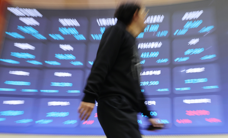 사진은 서울 여의도 한국거래소 홍보관에서 한 시민이 전광판 앞을 지나는 모습.[사진 연합뉴스]