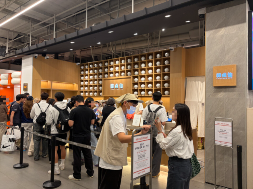 지난 10월 12일 서울 여의도 더현대 서울 지하 1층 한정선 매장에서 직원이 고객의 대기 번호를 확인하고 있다. [사진 강예슬 기자]
