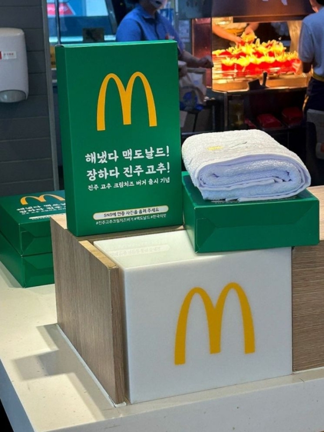 '한국의 맛 프로젝트'에 선정된 진주 지역의 맥도날드 매장에서 진행하는 기념 수건 증정 행사. '진주 고추 크림치즈 버거' 세트 구매 시 선착순 100명에게 증정한다. [이미지출처=온라인 커뮤니티 캡처]