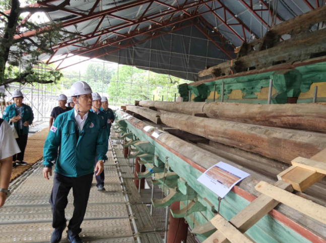 Choi Eung-chun, head of the Cultural Heritage Administration, inspecting the record of Sangryang found at the lower end of the finial during the roof repair at Dae Sungjeon in 'Seoul Munmyo and Sungkyunkwan' on the 24th.