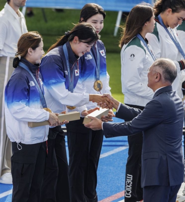 28일(현지시간) 프랑스 파리 레쟁발리드에 양궁 경기장에서 열린 2024 파리올림픽 양궁 여자단체전에서 올림픽 연속 10연패를 달성한 임시현(가운데)이 정의선 현대차 회장에게 금메달 부상을 전달받고 있다. [이미지출