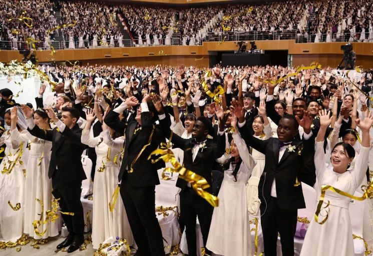 세계평화통일가정연합(옛 통일교)이 12일 경기 가평군 소재 청심평화월드센터에서 개최한 국제 합동결혼식에서 신랑·신부들이 밝은 표정으로 두손을 들고 있다.세계평화통일가정연합 제공