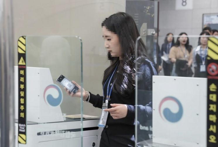 지난 8일 오후 경남 김해국제공항 검역소에서 한 시민이 질병관리청이 시범운영 중인 '큐코드 기반 페이퍼리스 검역'을 체험하고 있다.질병관리청