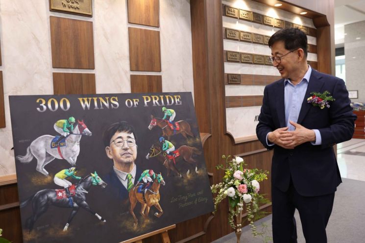 이종훈 마주가 300승 달성 기념으로 선물 받은 그림을 보며 기뻐하고 있다.렛츠런파크 부산경남 제공