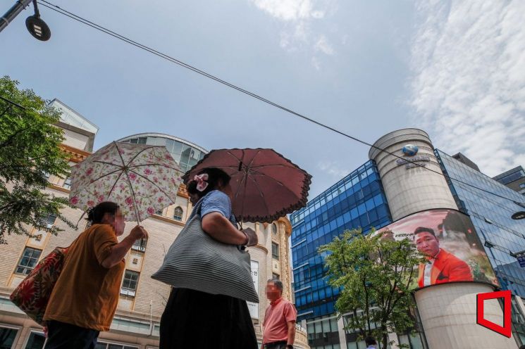 서울 중구 명동에서 시민들이 양산으로 햇볕을 가리고 있다. 강진형 기자