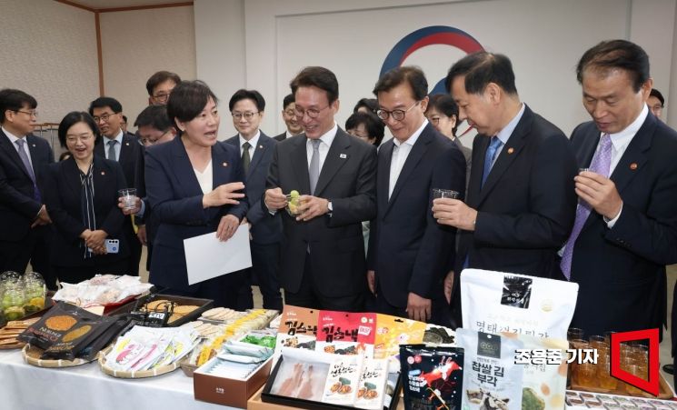 김민석 국무총리가 23일 서울 종로구 정부서울청사 국무위원 대기실에서 열린 농수산식품 소비촉진 행사에서 국내산 농수산물로 만든 가공식품과 추석 민생선물 세트 등을 살펴보며 맛보고