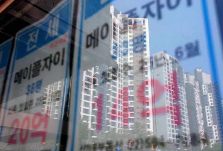 서울 시내의 한 부동산에 붙은 전세 매물 안내문에 인근 아파트 모습이 비치고 있다. 연합뉴스