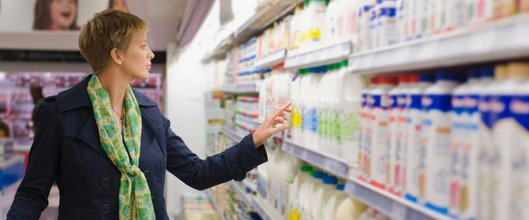 한 여성이 식료품 가게에서 테트라팩 용기로 포장된 음료를 고르고 있다. 테트라팩