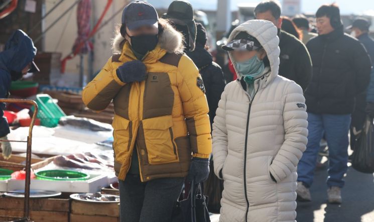 경남 창원시 마산합포구 마산어시장에서 두꺼운 패딩 점퍼 등을 착용한 시민이 찬 바람을 막으며 이동하고 있다.연합뉴스