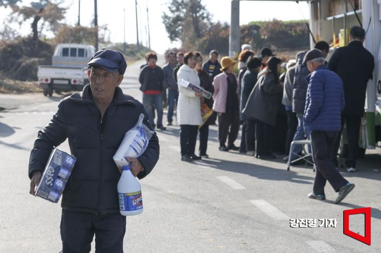 1일 충남 당진 합덕읍 도곡1리마을회관에 마련된 가가호호 찾아가는 당진농촌이동장터를 찾은 주민들이 물품을 구매하고 있다.강진형 기자