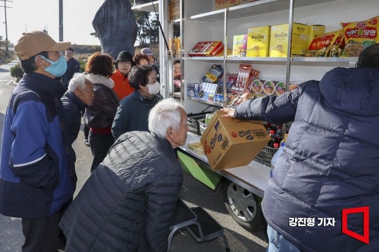 1일 충남 당진 합덕읍 도곡1리마을회관에 마련된 가가호호 찾아가는 당진농촌이동장터를 찾은 주민들이 물품을 구매하고 있다.강진형 기자