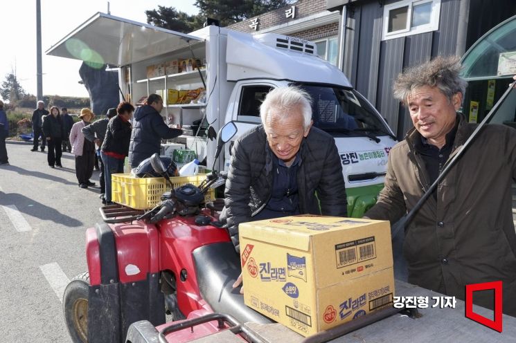 1일 충남 당진 합덕읍 도곡1리마을회관에 마련된 가가호호 찾아가는 당진농촌이동장터를 찾은 주민들이 물품을 구매하고 있다.강진형 기자