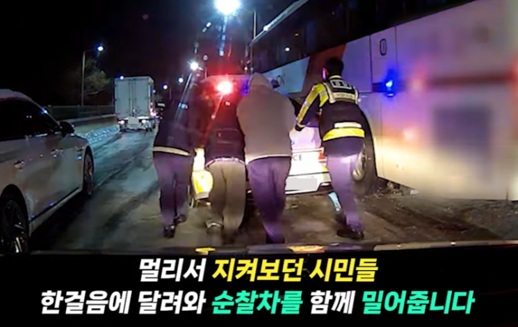 지난 4일 경기 남양주의 한 도로에서 긴급 후송을 하던 순찰차가 결빙 구간에 빠지자 시민들이 달려와 경찰관과 함께 순찰차를 밀어 바퀴가 빠져나올 수 있도록 돕고 있다.유튜브 채널 '대한민국 경찰청