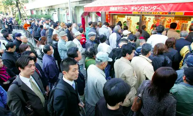 2004년 일본 도쿄에 위치한 점보 복권 매장 앞.복권을 구매하려는 사람들이 길게 줄 서있다.아사히신문