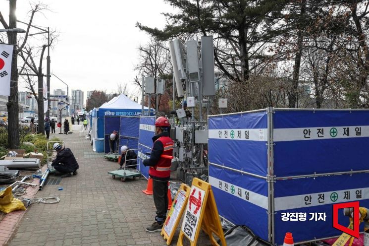 윤석열 대통령 탄핵소추안 재표결을 앞둔 12일 서울 여의도 국회 인근에서 통신사 작업자들이 원활한 통신 사용을 위해 기지국을 설치하고 있다.강진형 기자